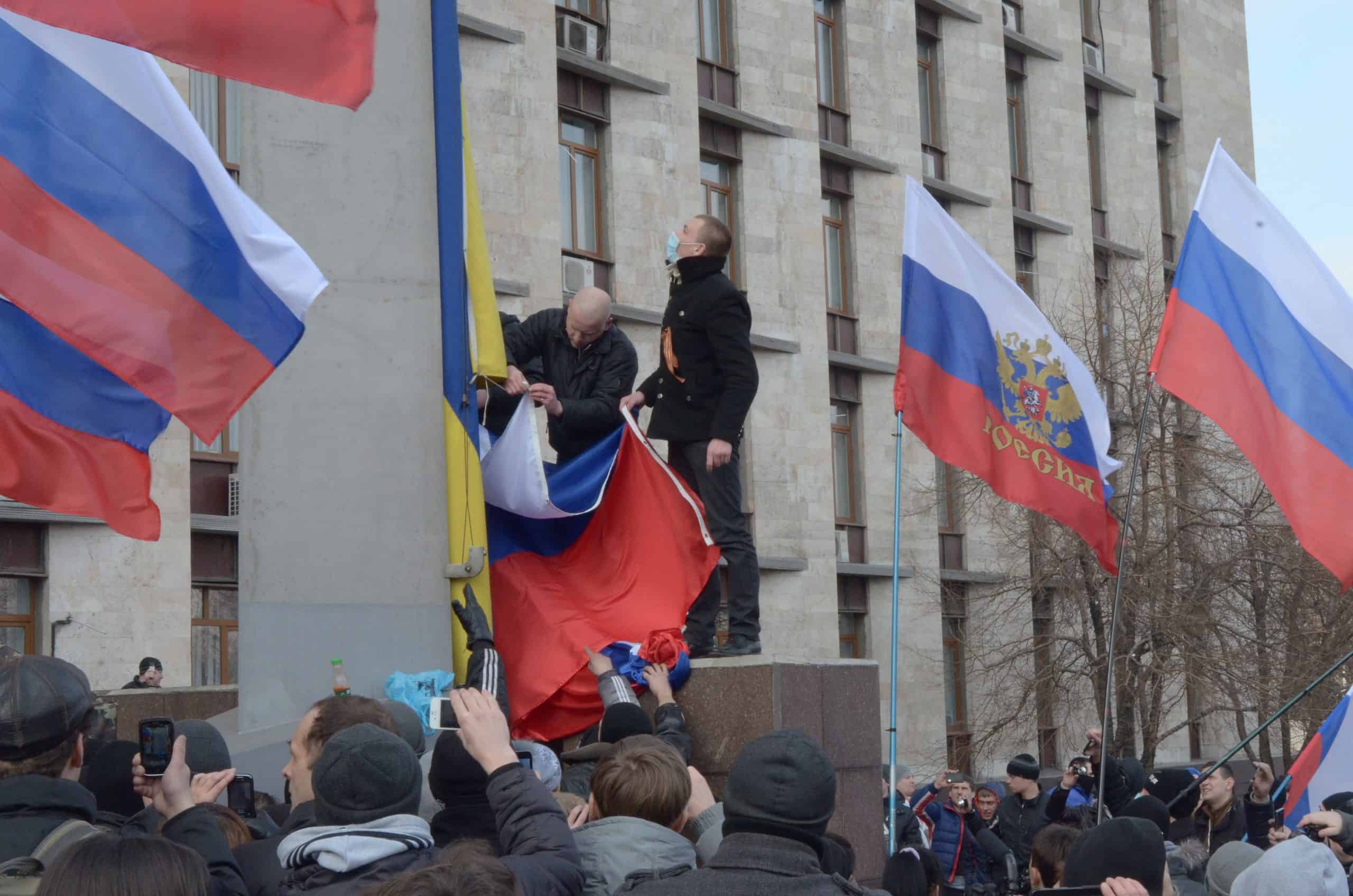 Проросійські протестувальники піднімають російський прапор на флагштоці перед будівлею Донецької ОДА. 1 березня 2014