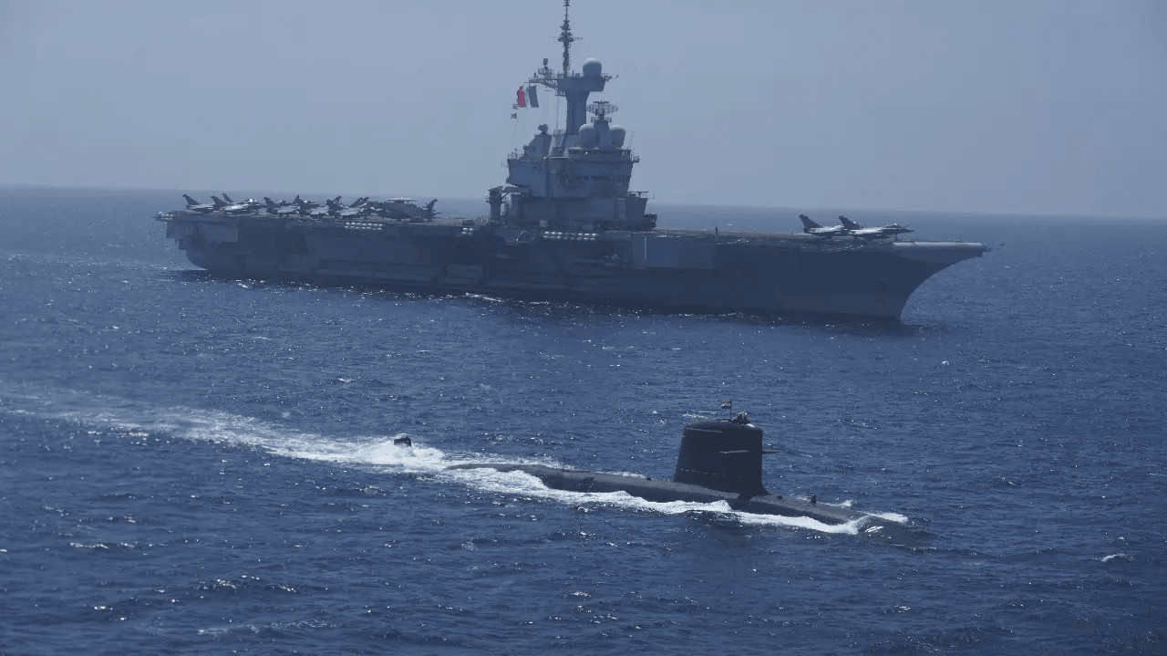 Підводний човен ВМС Індії типу Scorpene пливе поруч з авіаносцем ВМС Франції «Шарль де Голль» під час навчань VARUNA
