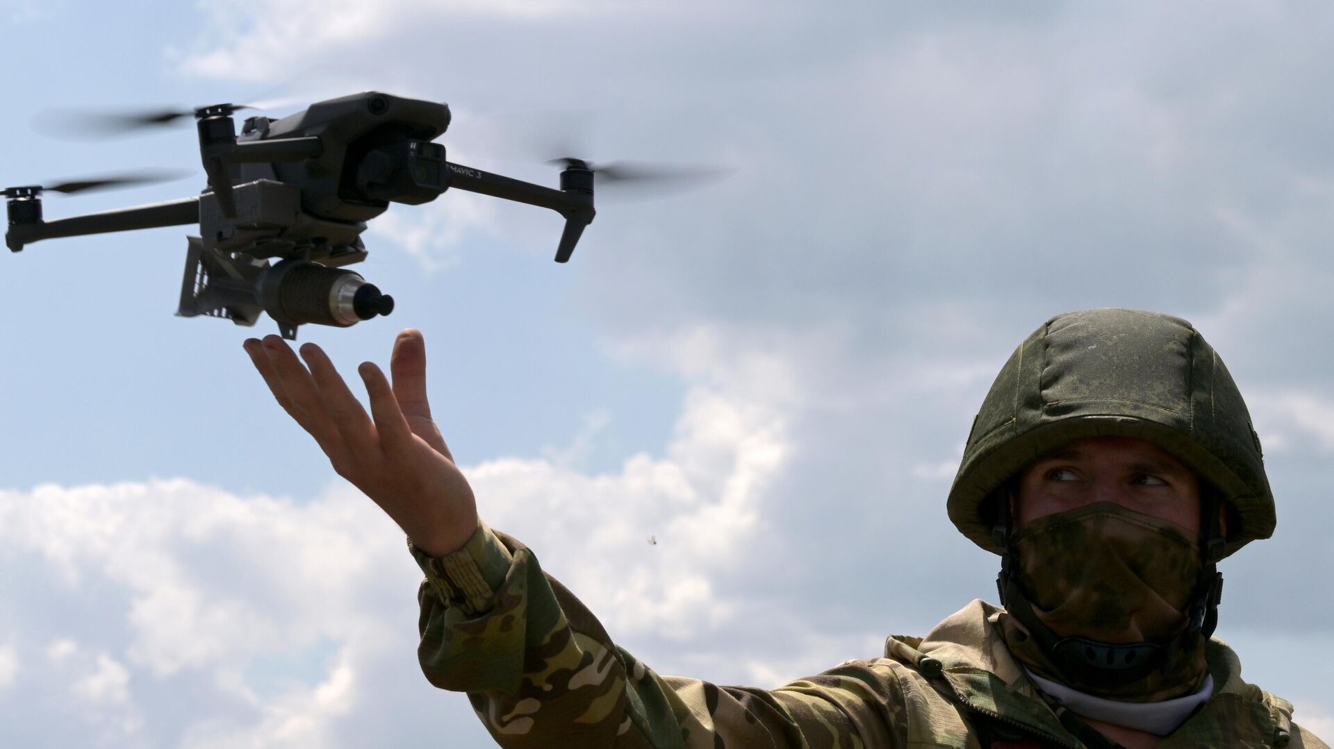 A Russian soldier launches a DJI Mavic 3 drone with a free-fall bomb.