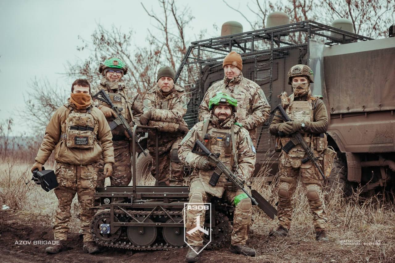 Оператори НРК на тлі бронемашини «Джура», що згодом буде підбита дроном в 7 км від фронту під час доставки наземного дрона, 2025 рік. Фото: 12 бригада НГУ «Азов»