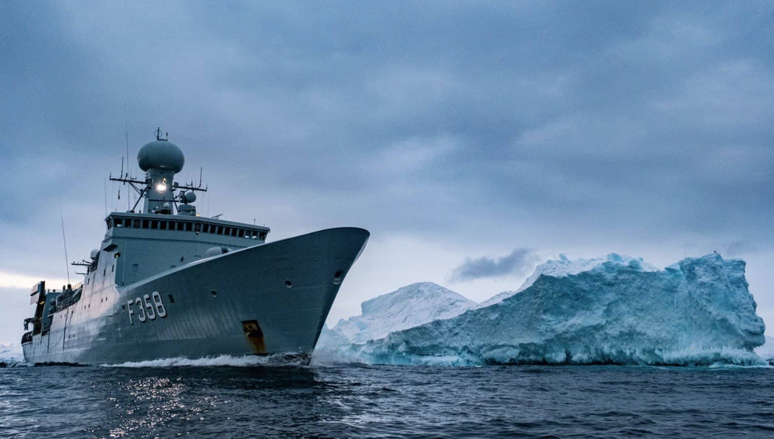 The Royal Danish Navy frigate HDMS Triton passes an iceberg in the waters around Greenland, November 6, 2022. Photo credits: nato.int