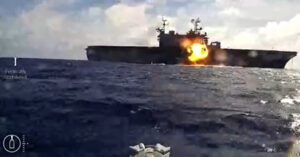 A U.S. Navy kamikaze sea drone observes the strike on the decommissioned amphibious assault ship USS Peleliu